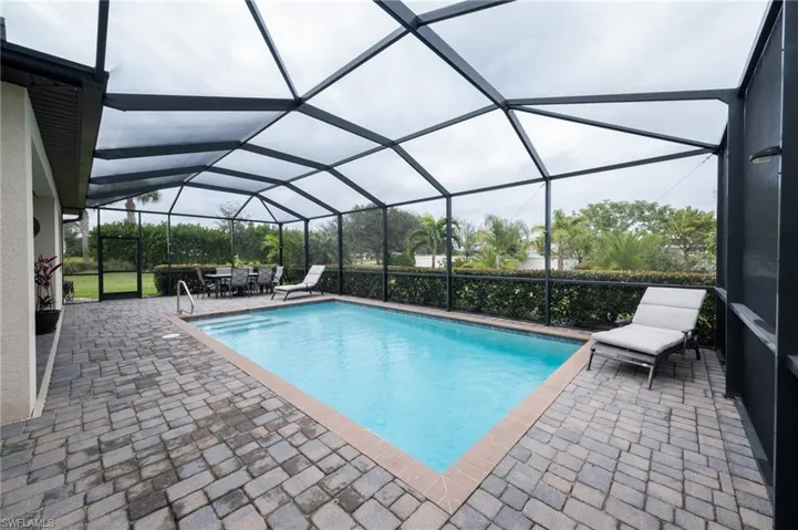 View of swimming pool with a lanai and sunbathing area