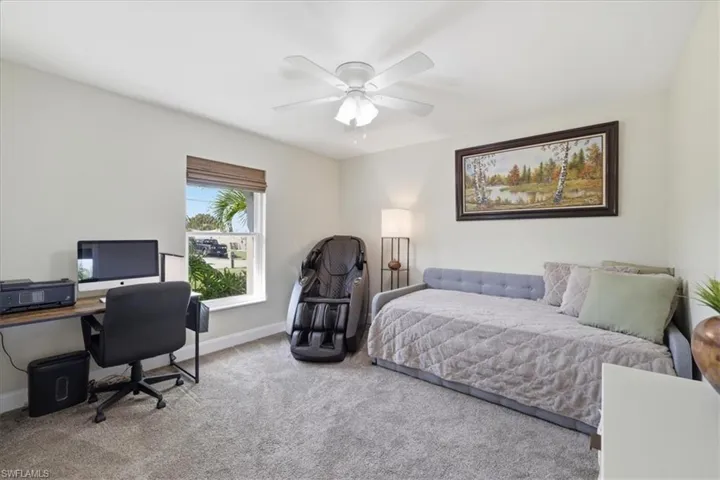 Bedroom with an office area, carpet flooring, and ceiling fan