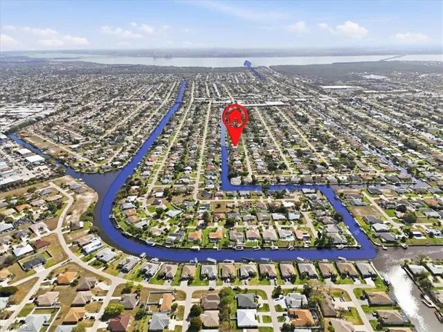 Aerial view of property and surrounding area with a large body of water and nearby suburban area