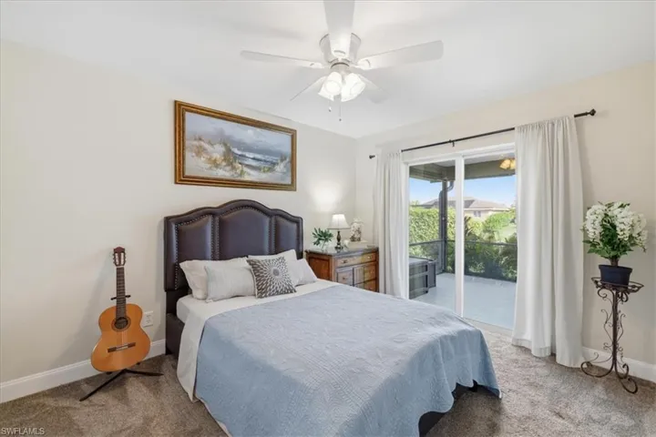 Bedroom featuring light colored carpet, access to exterior, and a ceiling fan