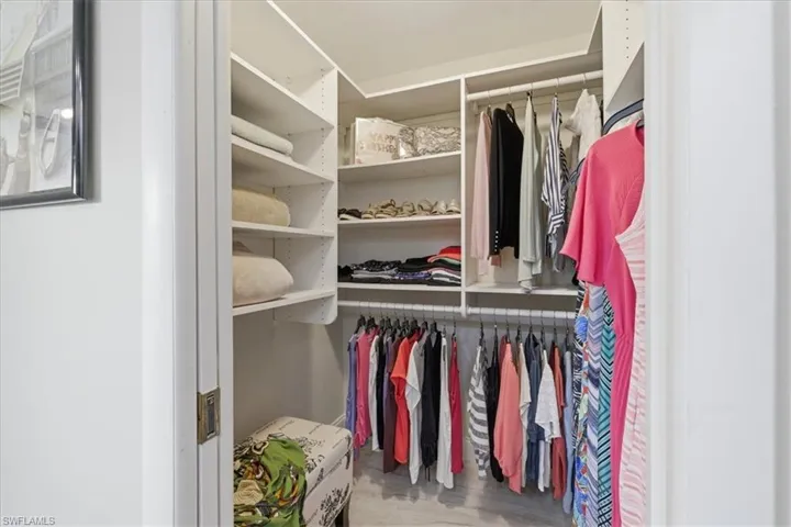 Walk in closet with light wood-style floors