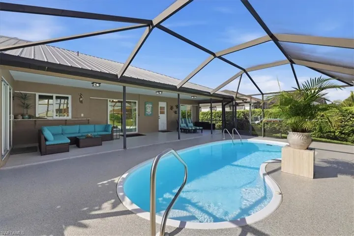 Swimming pool featuring outdoor furniture, a sunroom, a patio, and glass enclosure