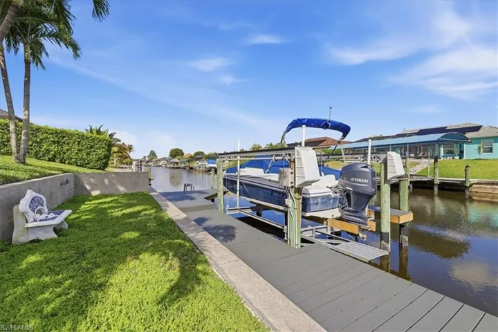 Dock area featuring a yard, boat lift, and a water view