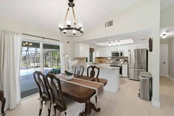 Dining space featuring hanging lights and vaulted ceiling