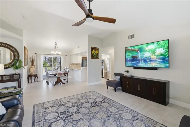 Living area with hanging lights, vaulted ceiling, and a ceiling fan