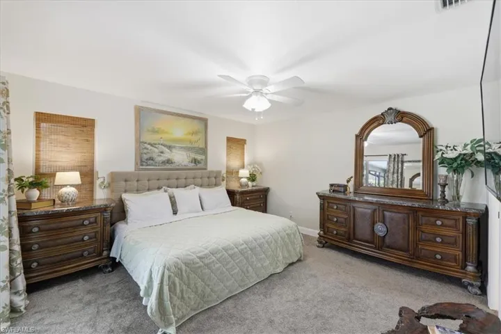 Bedroom with light carpet and a ceiling fan