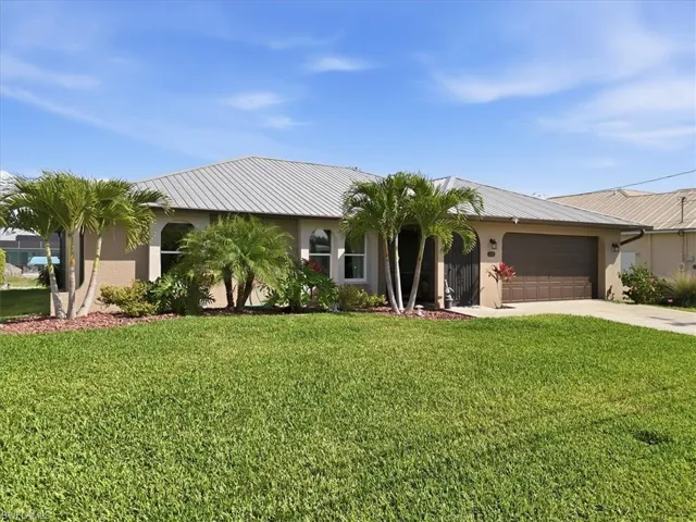 Ranch-style home featuring stucco siding, a garage, driveway, and a front yard