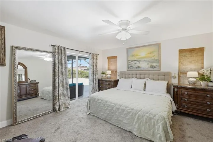 Bedroom with light colored carpet, access to outside, and ceiling fan