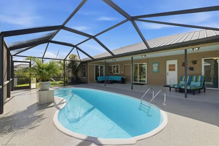 Swimming pool with outdoor lounge area, a patio area, a sunroom, and a lanai