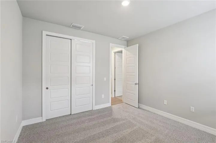 Unfurnished bedroom with carpet flooring and a closet