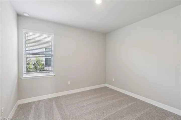 Carpeted empty room with baseboards