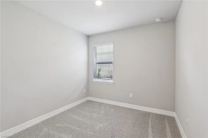 Carpeted empty room featuring baseboards