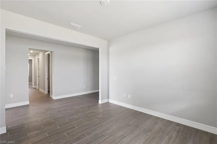 Spare room with dark wood-style flooring