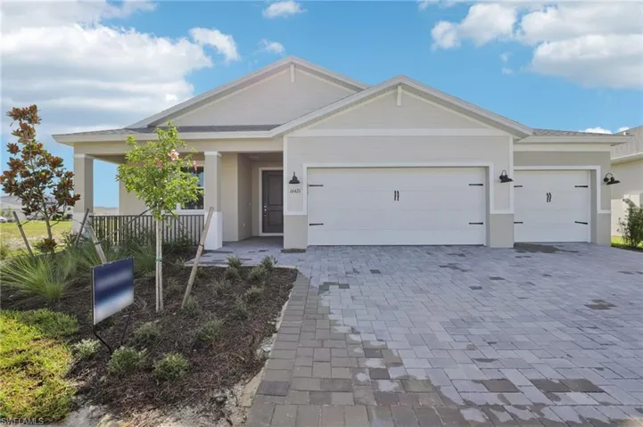 View of front facade featuring an attached garage, decorative driveway, and stucco siding