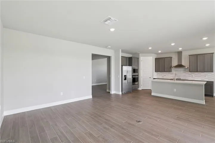 Kitchen featuring open floor plan, light countertops, light wood-style flooring, appliances with stainless steel finishes, and recessed lighting