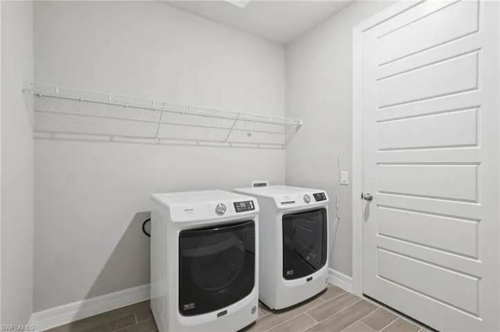 Laundry room with separate washer and dryer and wood finish floors