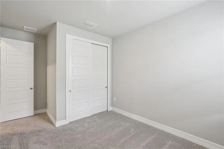 Unfurnished bedroom with carpet flooring and a closet