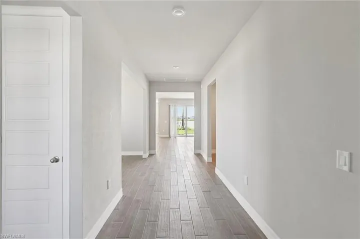 Corridor with wood finished floors and baseboards