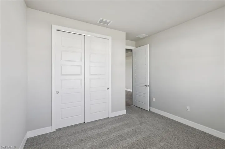 Unfurnished bedroom with carpet and a closet