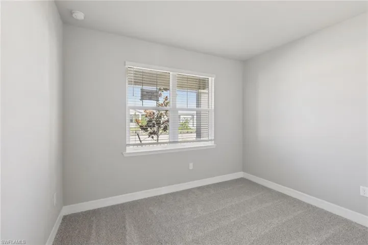 Carpeted empty room with baseboards
