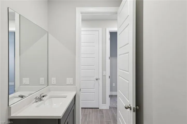 Bathroom featuring vanity and wood finish floors