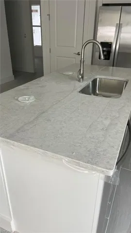 Quartz countertops and stainless steel Kohler, farmhouse sink and pull-down faucet