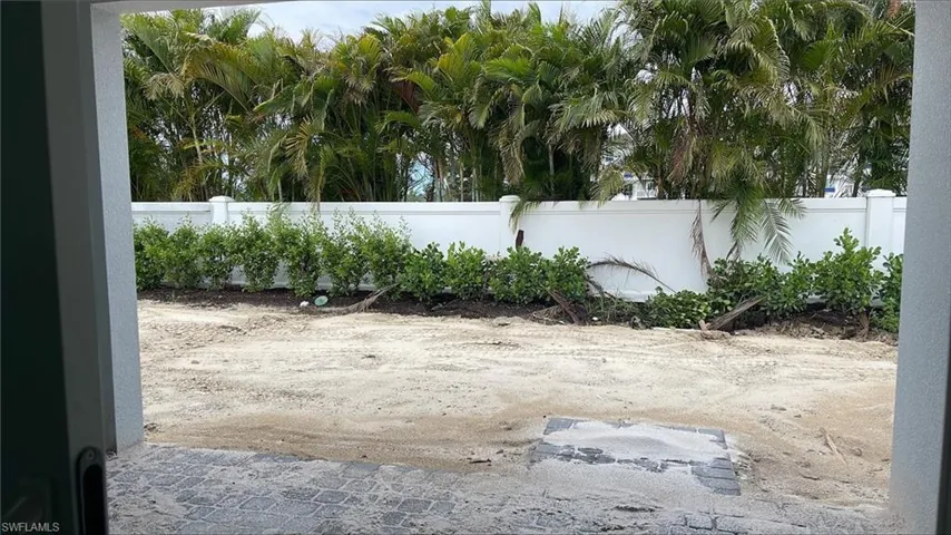 Backyard view with covered lanai, private fencing and landscaping