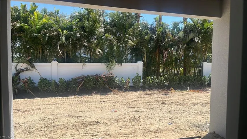Backyard view with covered lanai, private fencing and landscaping