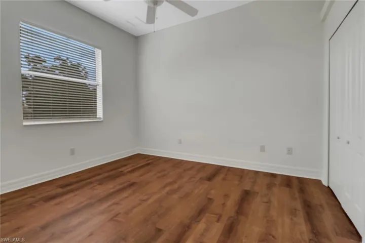 Unfurnished bedroom featuring a closet, ceiling fan, and dark hardwood / wood-style flooring