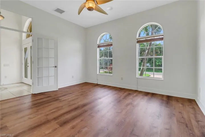 Spare room with ceiling fan, plenty of natural light, light hardwood / wood-style flooring, and french doors