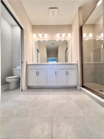Bathroom with vanity, toilet, and a shower with door