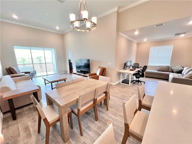 Dining area with ornamental molding and a notable chandelier
