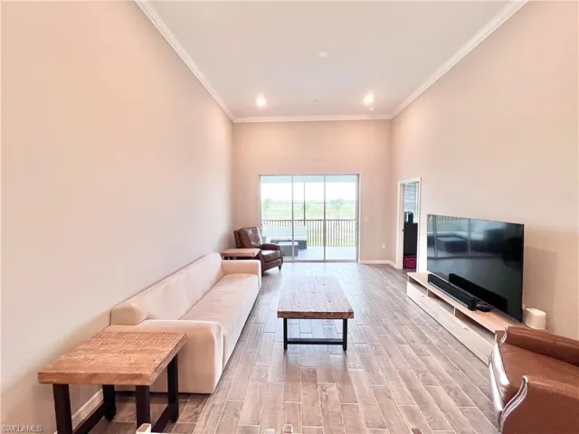 Living room with light hardwood / wood-style floors and crown molding