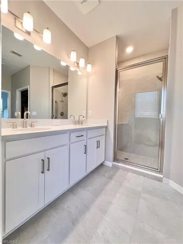Bathroom featuring a shower with door and vanity