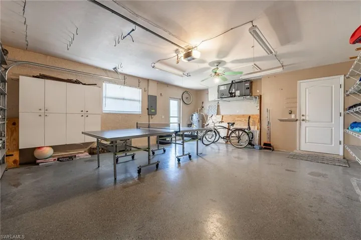 Spacious utility garage featuring concrete flooring, track lighting, and a ceiling fan