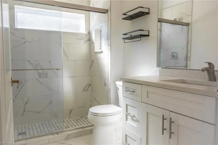 Full bathroom with vanity and a marble finish shower