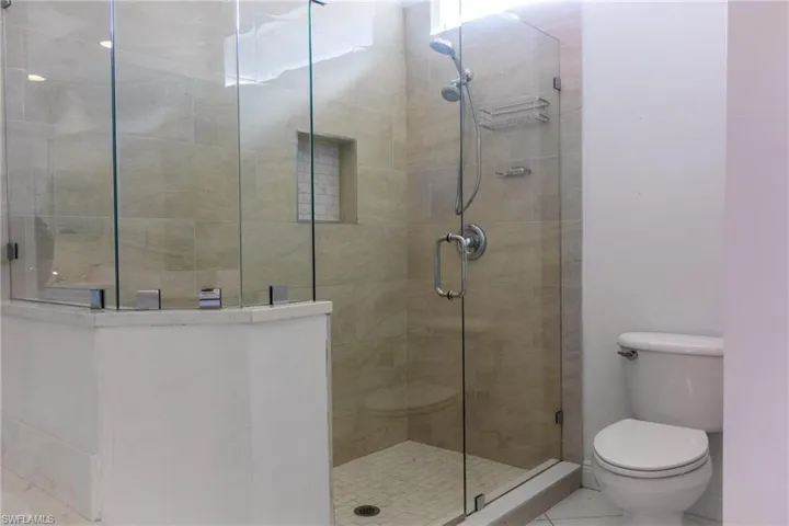 Full bath with a stall shower and tile patterned flooring