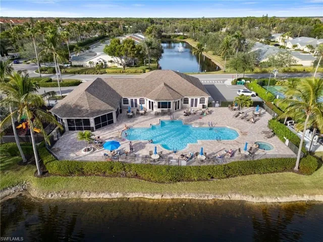 Drone / aerial view of a nearby body of water and a pool area