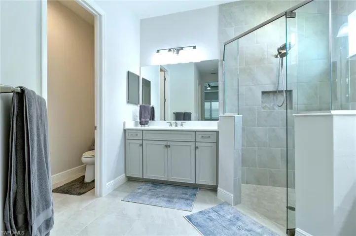 Primary bathroom with two vanities and a large walk-in shower
