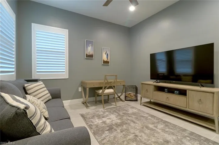 Flex space with plantation shutters, tile floors and fence doors with access off the great room.