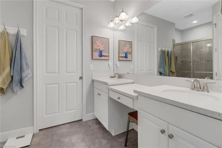 Bathroom with tile patterned flooring, vanity, and a shower with shower door