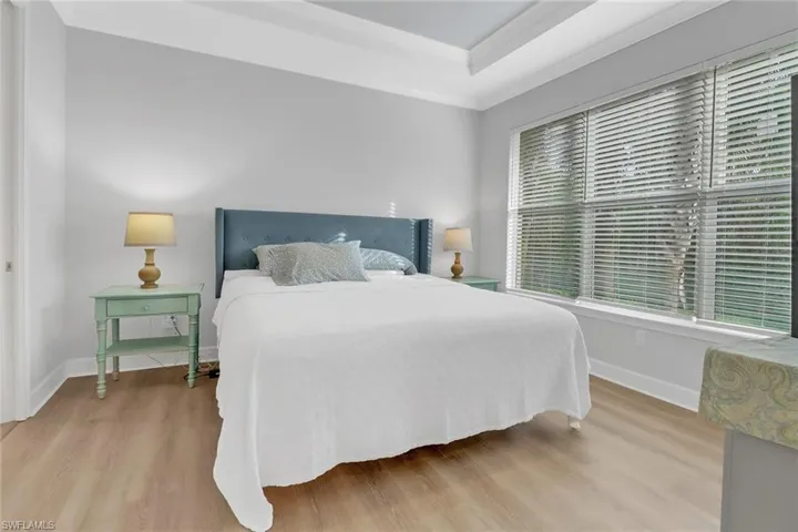 Bedroom featuring multiple windows, crown molding, and light wood-type flooring