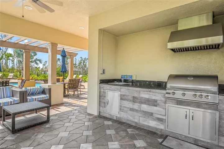 View of patio featuring sink, ceiling fan, area for grilling, an outdoor kitchen, and a pergola