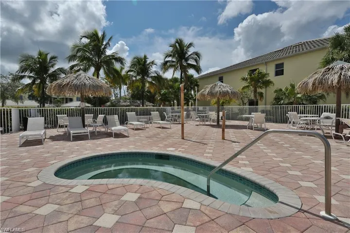 View of swimming pool with a hot tub and a patio area