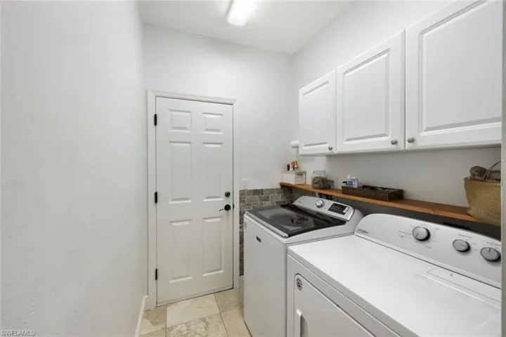 Laundry room with mud sink and upper cabinets for additional storage.
