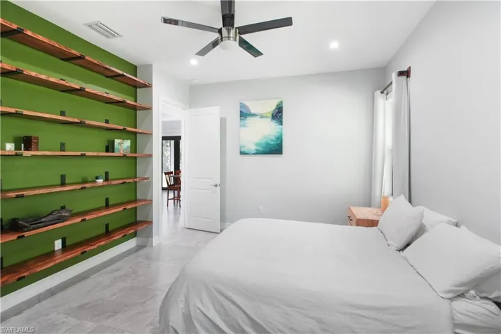 Tiled bedroom featuring ceiling fan