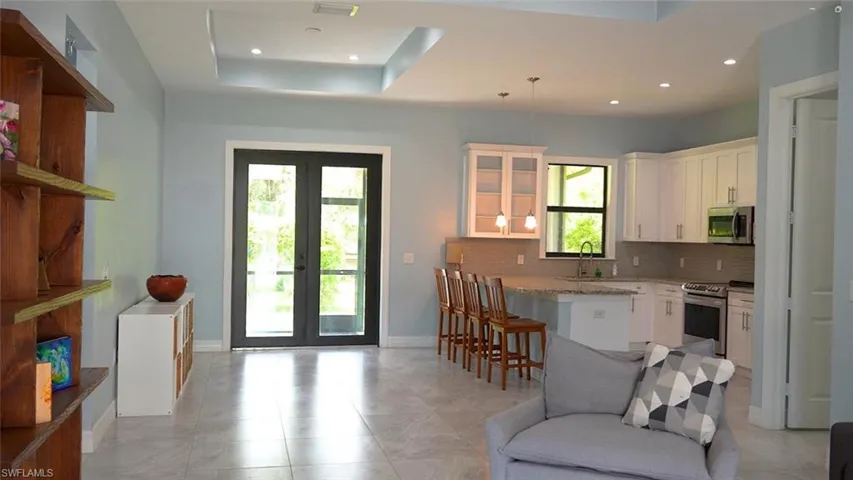 Kitchen featuring a wealth of natural light, french doors, a raised ceiling, and stainless steel appliances