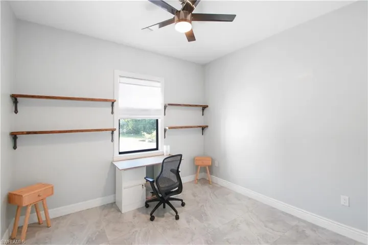 Office space with ceiling fan and light tile floors