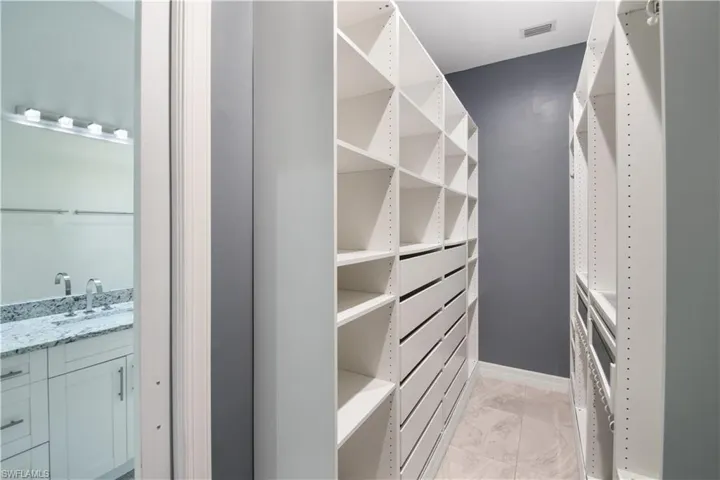 Walk in closet with sink and light tile floors