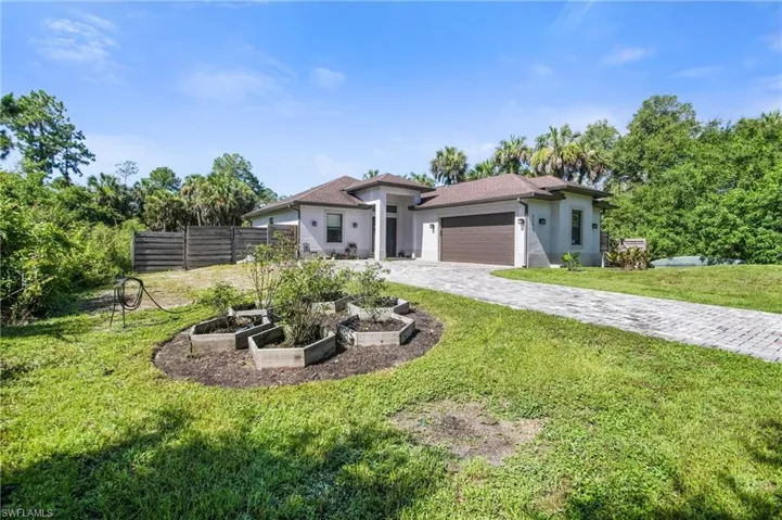View of front of home with a front yard and a garage